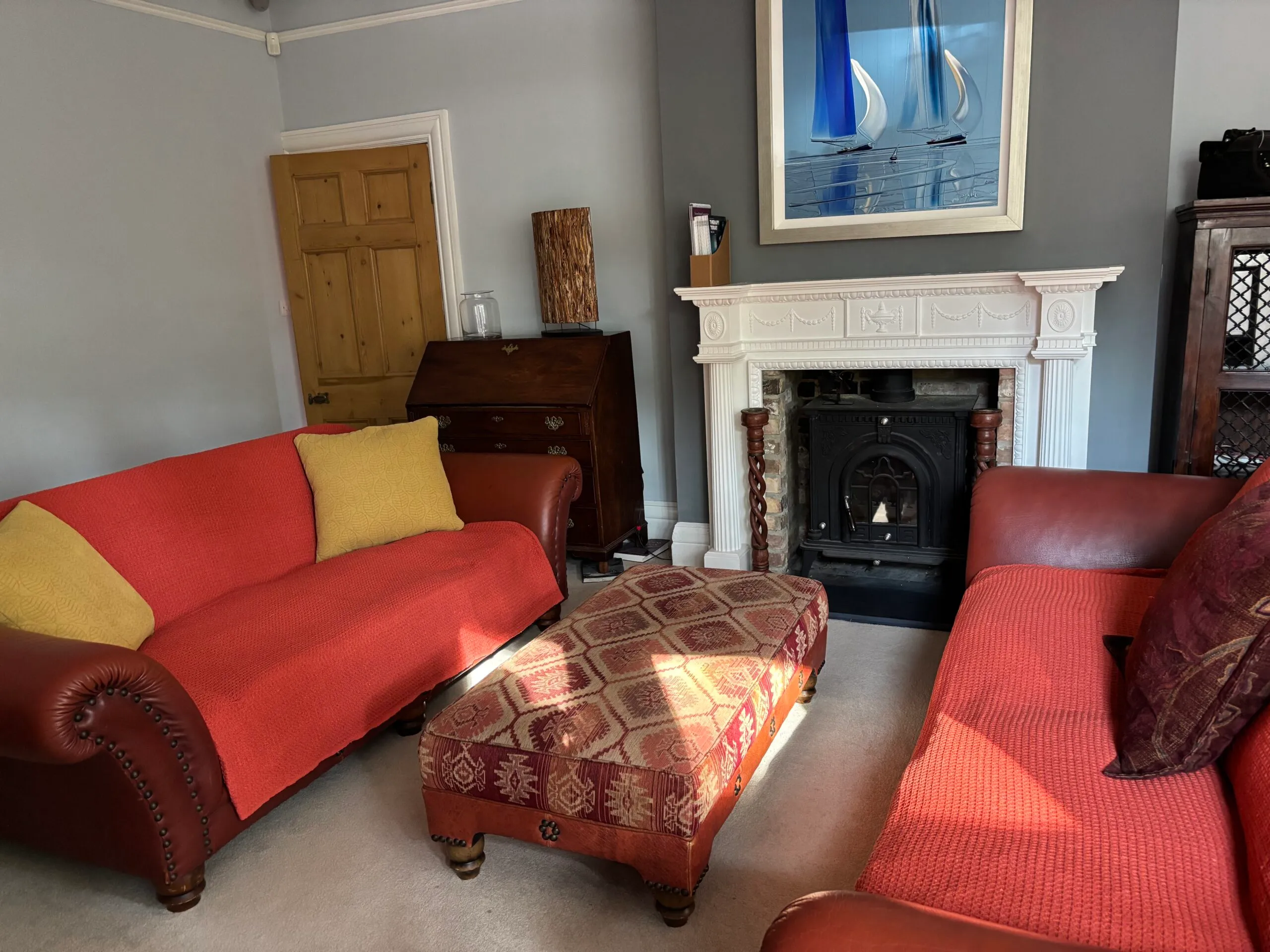 Counselling room with red sofas and a fireplace